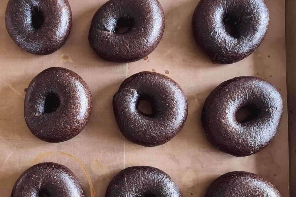 Pumpernickel bagels baked on a baking sheet