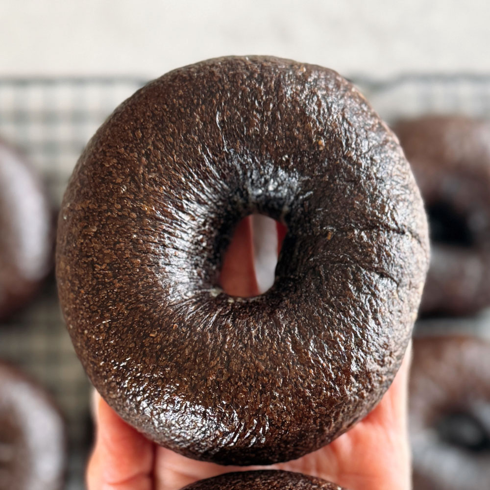 Pumpernickel sourdough bagel on a palm of hand