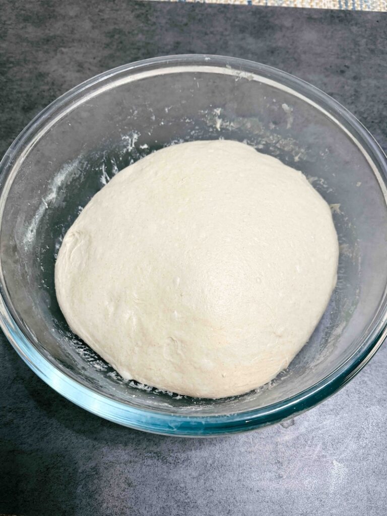 Dough bulk fermenting in glass bowl