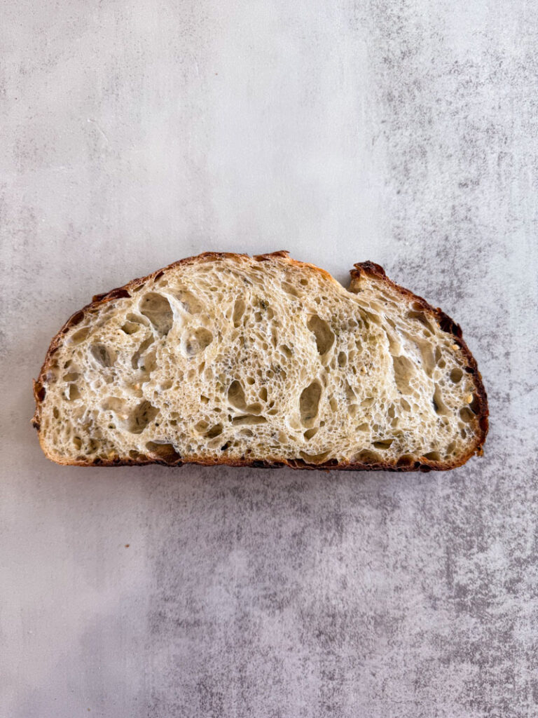 One slice of sourdough loaf with italian herbs garlic and parmesan inclusions